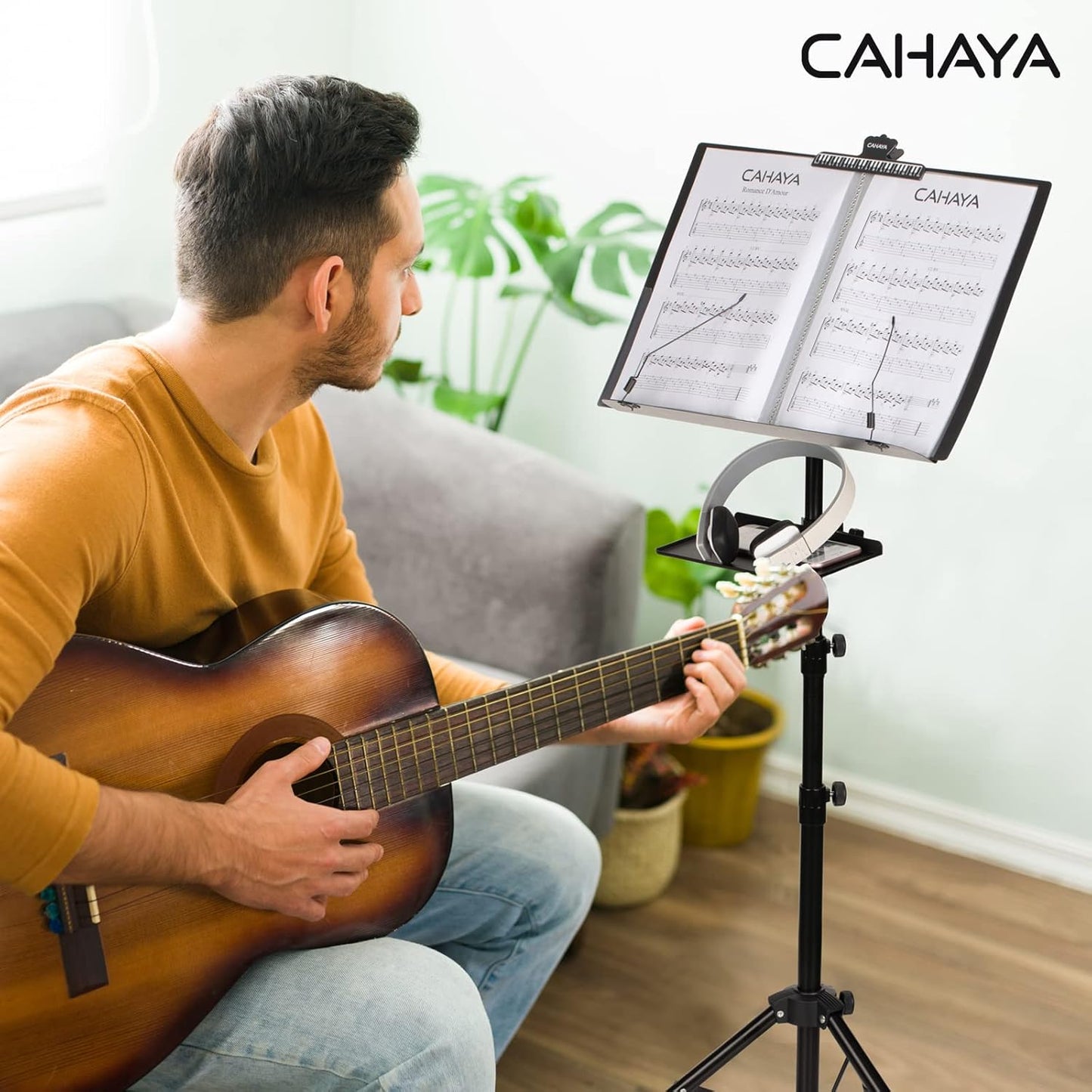 Man playing guitar with a CAHAYA music stand